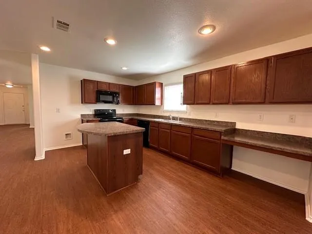 a kitchen with stainless steel appliances granite countertop a sink counter space and cabinets