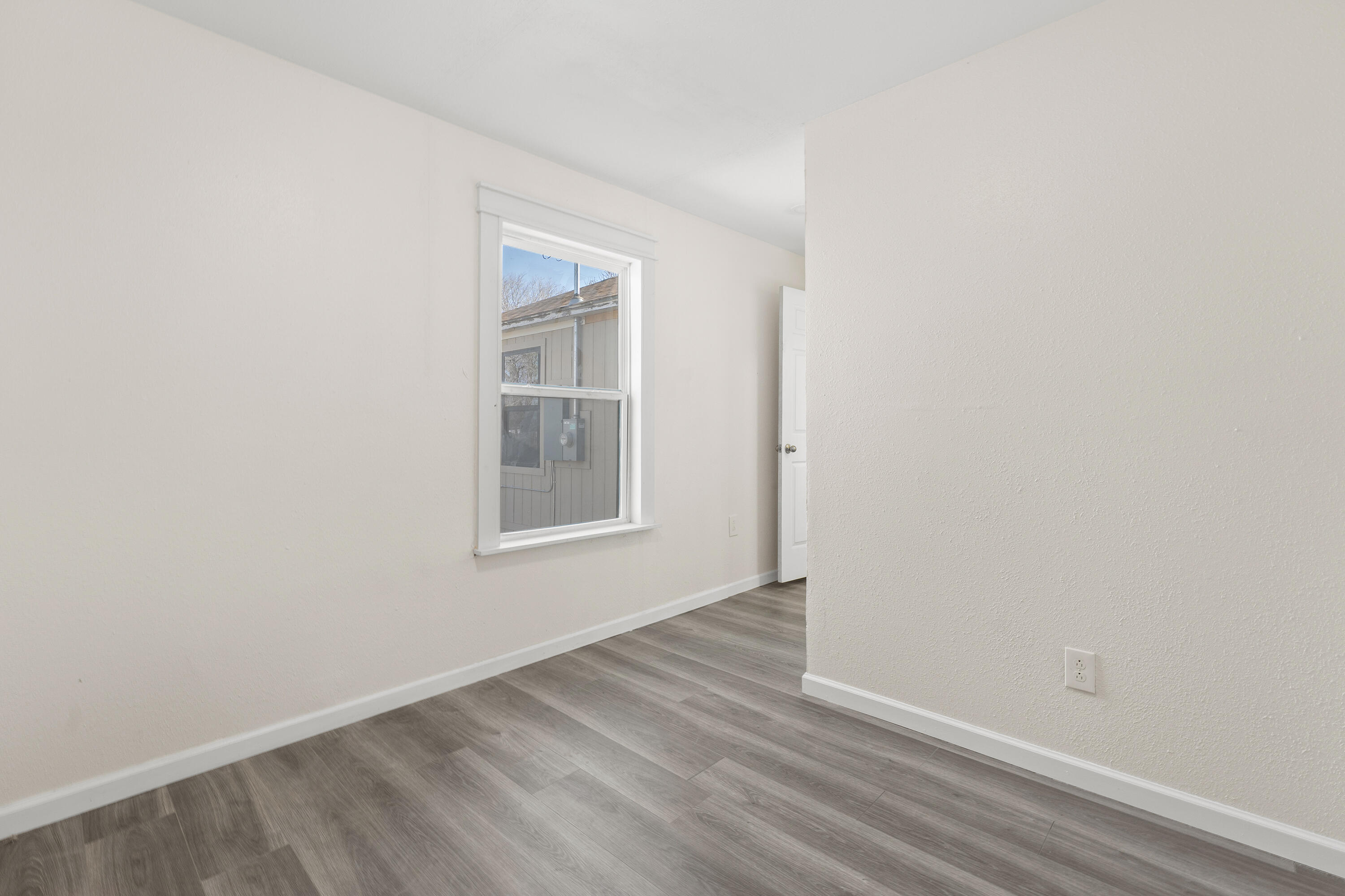 4820 39th Street Lubbock, TX 79414 - Photo 13 of 21 a view of an empty room with wooden floor and a window