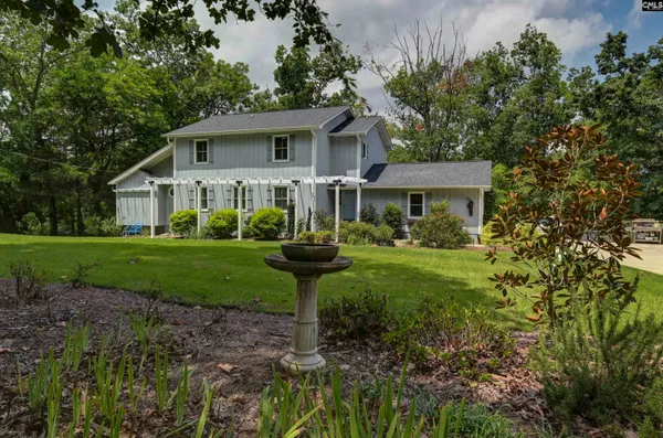 a view of a house with a yard and sitting area