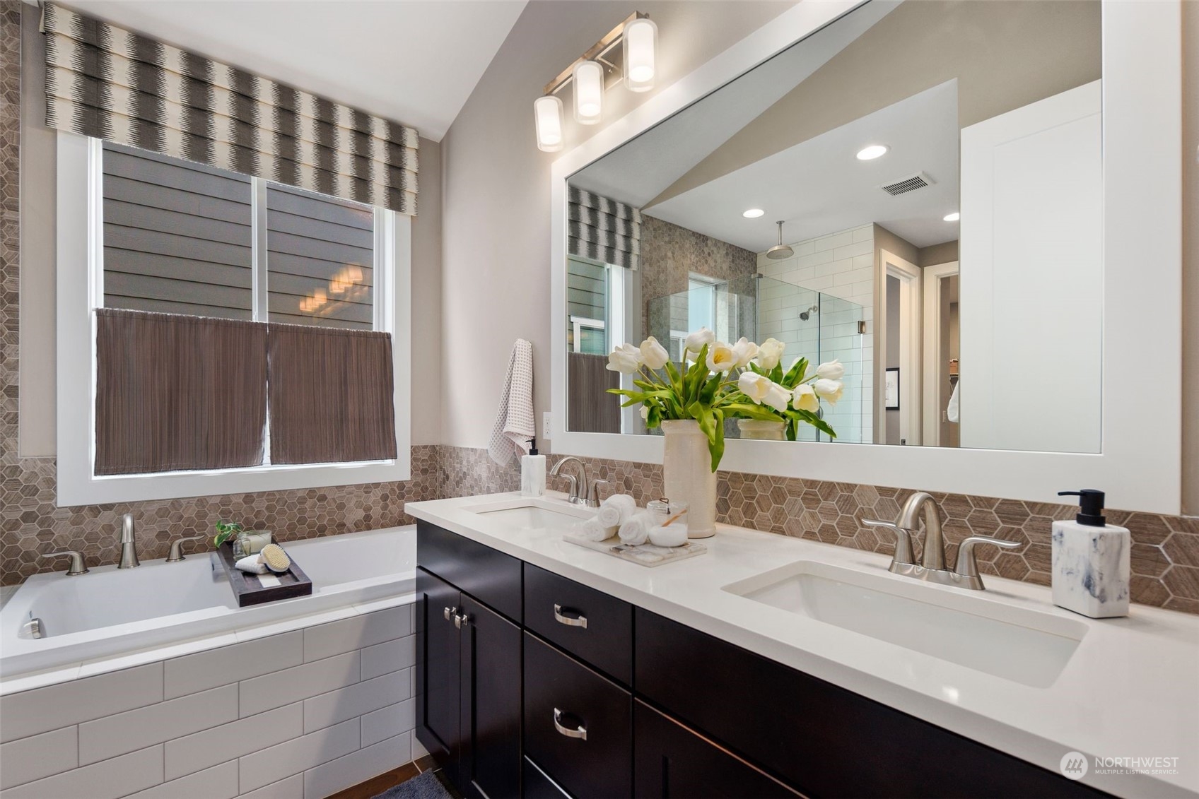 263 Graham Avenue Southeast Renton, WA 98059 - Photo 17 of 40 a bathroom with a double vanity sink a mirror and a bathtub