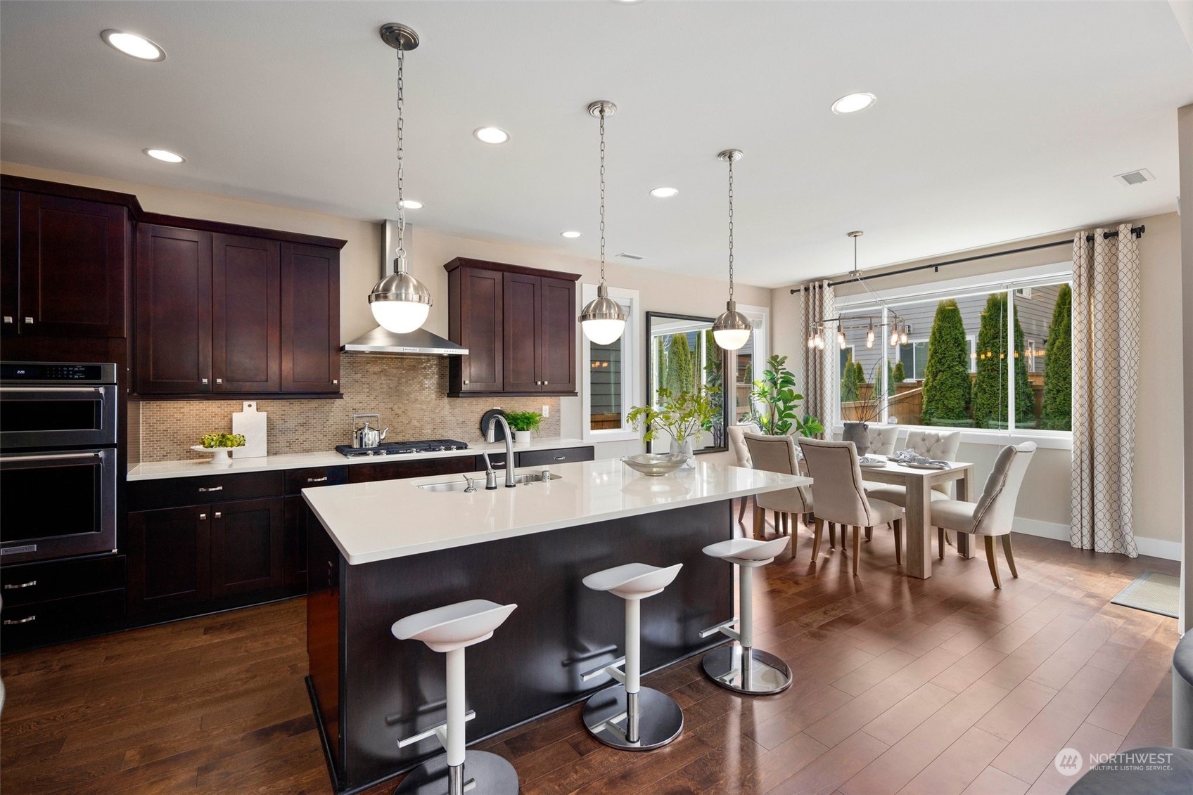263 Graham Avenue Southeast Renton, WA 98059 - Photo 9 of 40 a kitchen with stainless steel appliances granite countertop a stove a refrigerator a kitchen island a dining table and chairs with wooden floor