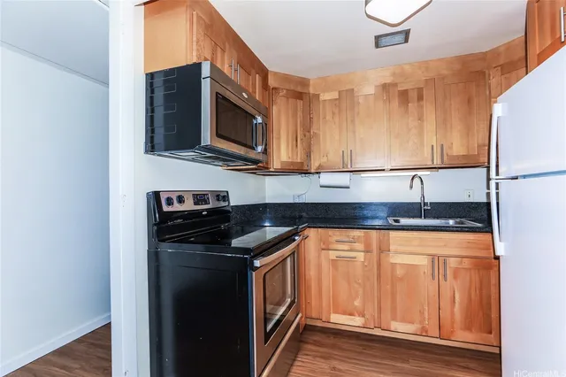 a kitchen with stainless steel appliances granite countertop a stove microwave and sink