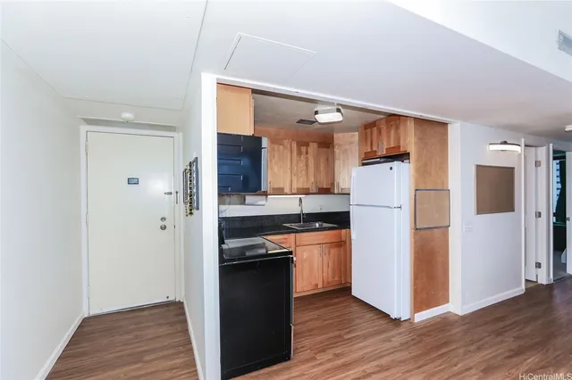 a kitchen with a refrigerator and a stove top oven