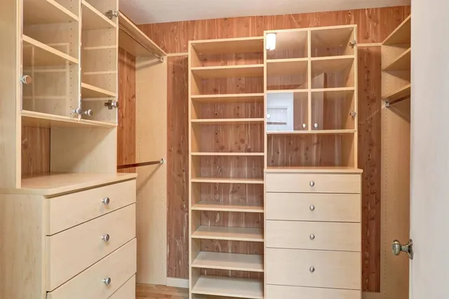 an aerial view of residential houses with outdoor space and trees