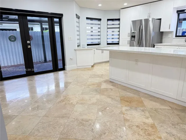 a large kitchen with stainless steel appliances a refrigerator and a stove top oven