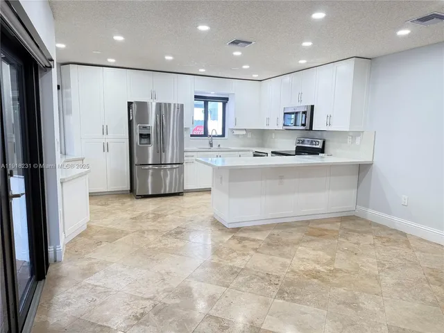 a view of an empty room with a kitchen