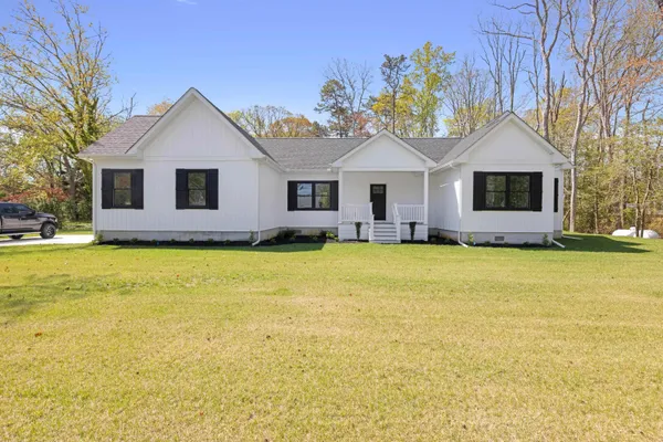 a front view of house with yard and trees around
