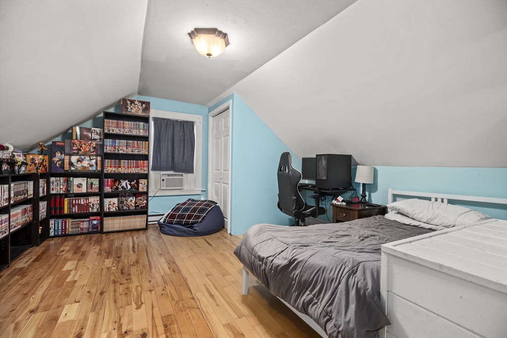 145 High Street, Unit 2 Danvers, MA 01923 - Photo 26 of 40 a bedroom with a bed and a book shelf