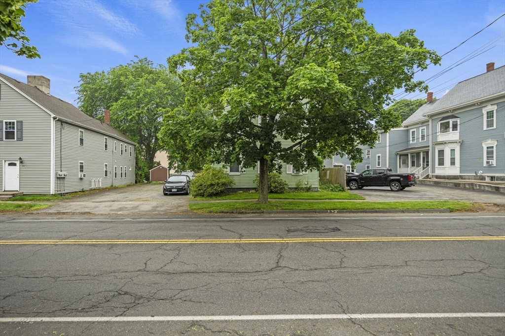 145 High Street, Unit 2 Danvers, MA 01923 - Photo 38 of 40 a view of a white house in a big yard with a large tree