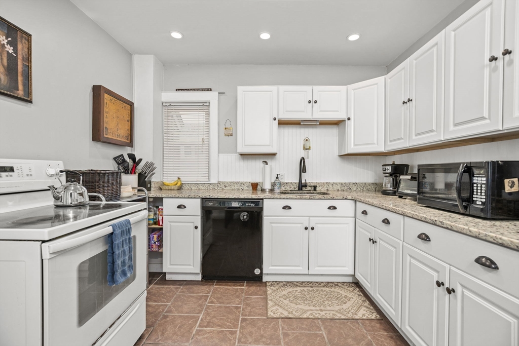 145 High Street, Unit 2 Danvers, MA 01923 - Photo 4 of 40 a kitchen with stainless steel appliances granite countertop a stove sink and cabinets