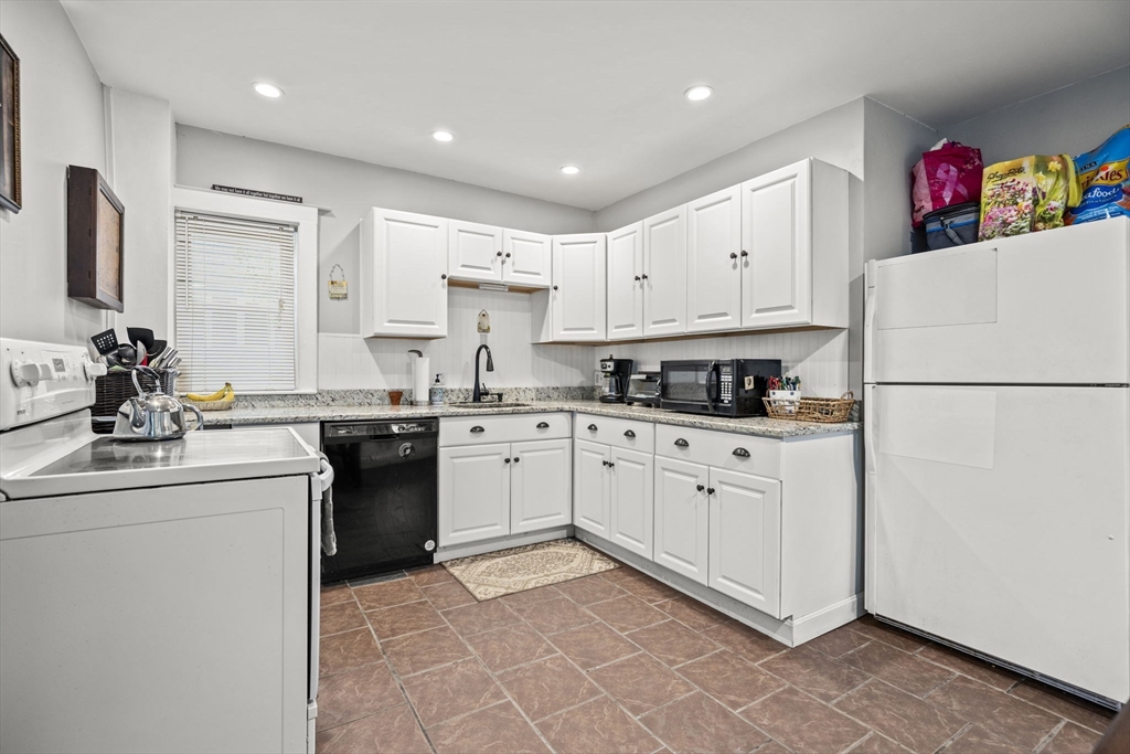 145 High Street, Unit 2 Danvers, MA 01923 - Photo 5 of 40 a kitchen with kitchen island granite countertop cabinets and white appliances