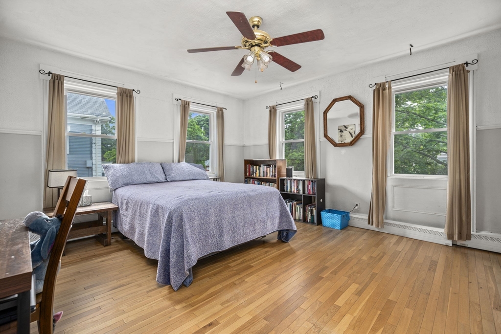 145 High Street, Unit 2 Danvers, MA 01923 - Photo 10 of 40 a spacious bedroom with a bed a dresser and a large window
