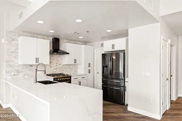 a kitchen with stainless steel appliances a refrigerator and a stove top oven