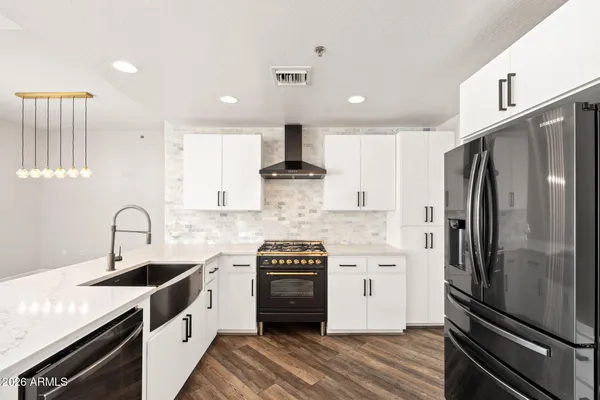a kitchen with stainless steel appliances a refrigerator sink and stove
