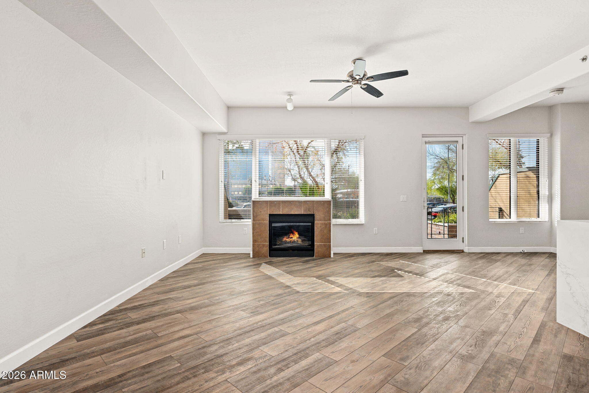 16 West Encanto Boulevard, Unit 12 Phoenix, AZ 85003 - Photo 5 of 42 an empty room with windows fireplace and wooden floor