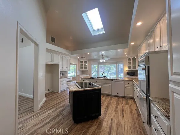 a kitchen with refrigerator a stove and wooden floor