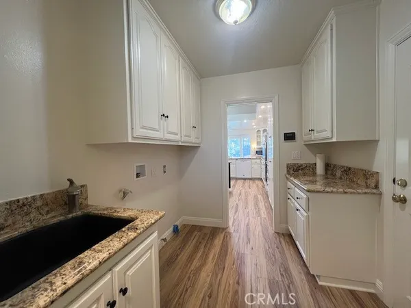 a kitchen with granite countertop a sink dishwasher stove and cabinets