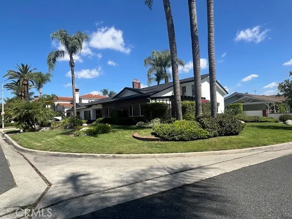 a front view of a house with a yard and potted plants