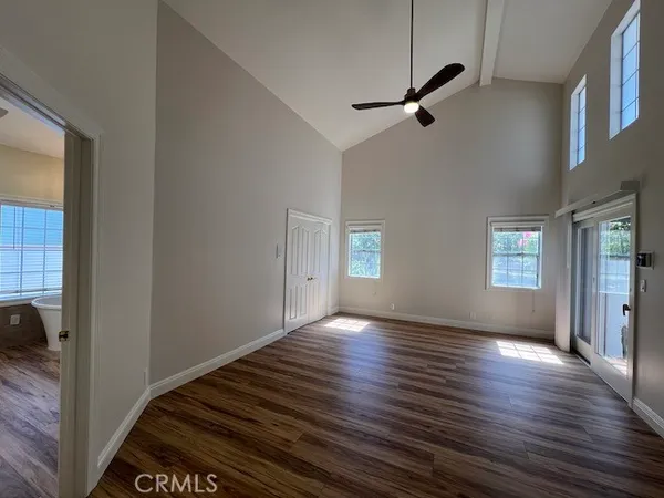 a view of a livingroom with wooden floor and a ceiling fan