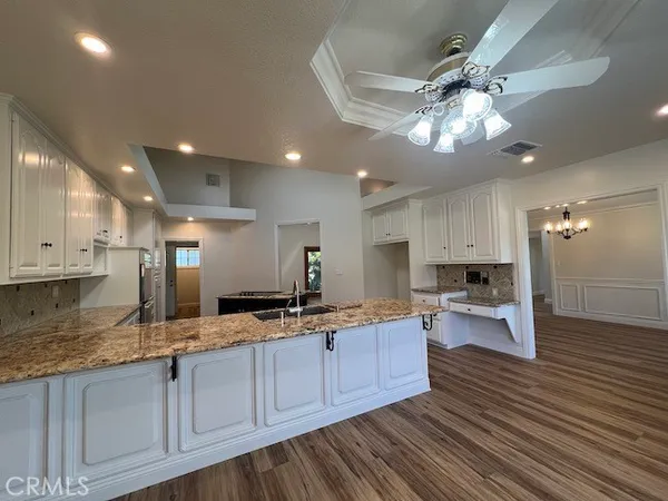 a large kitchen with stainless steel appliances granite countertop a lot of counter space and wooden floor