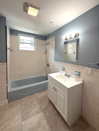 a bathroom with a sink a large mirror and a bathtub