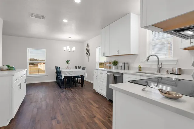 a kitchen with a sink cabinets and wooden floor