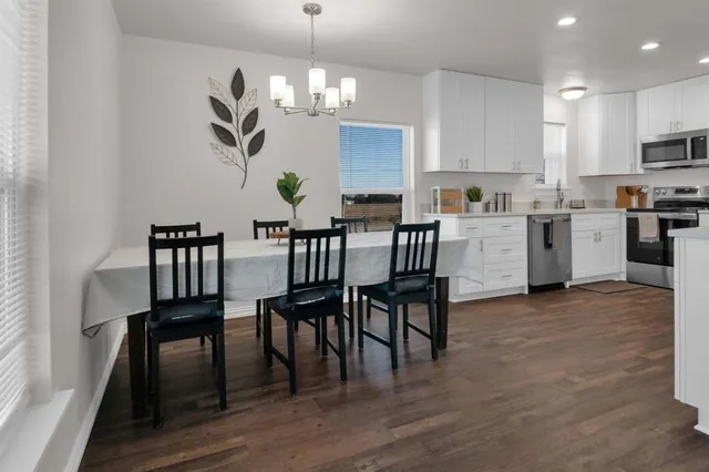 a view of dining room and kitchen with furniture wooden floor and chandelier