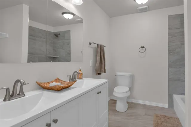 a bathroom with a sink a toilet and a mirror