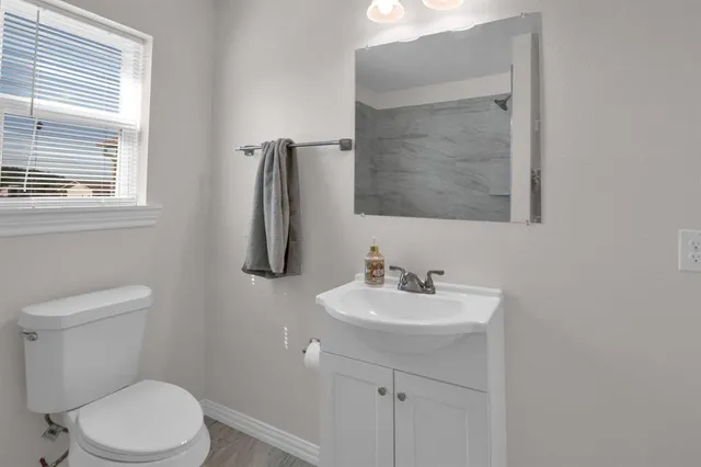 a bathroom with a toilet sink and mirror