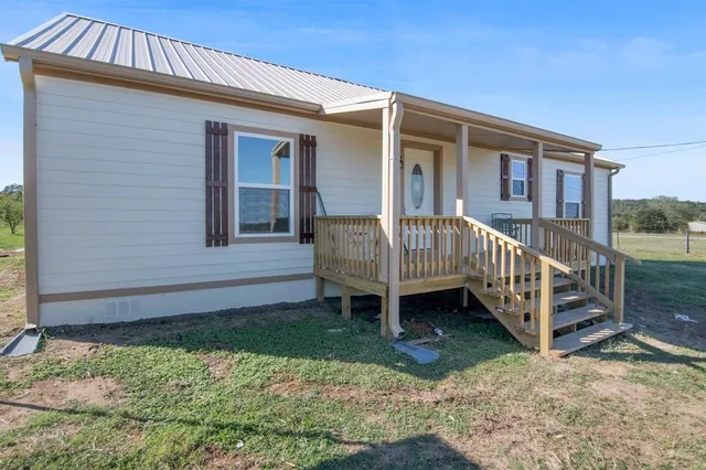 a view of a house with a yard and deck
