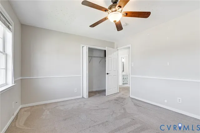 an empty room with closet and windows