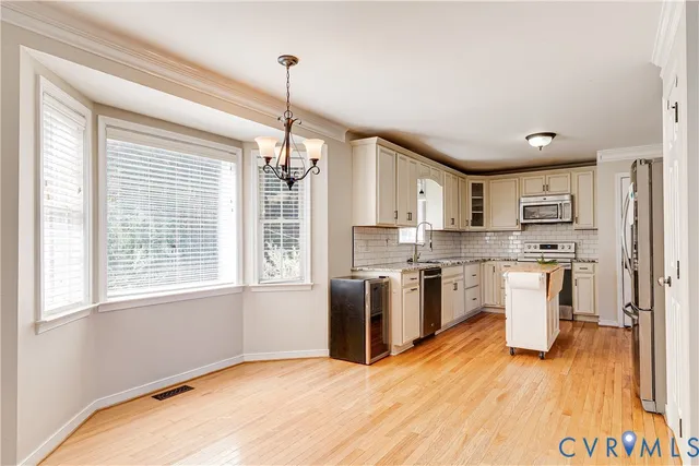 a kitchen with a refrigerator and a wooden floor