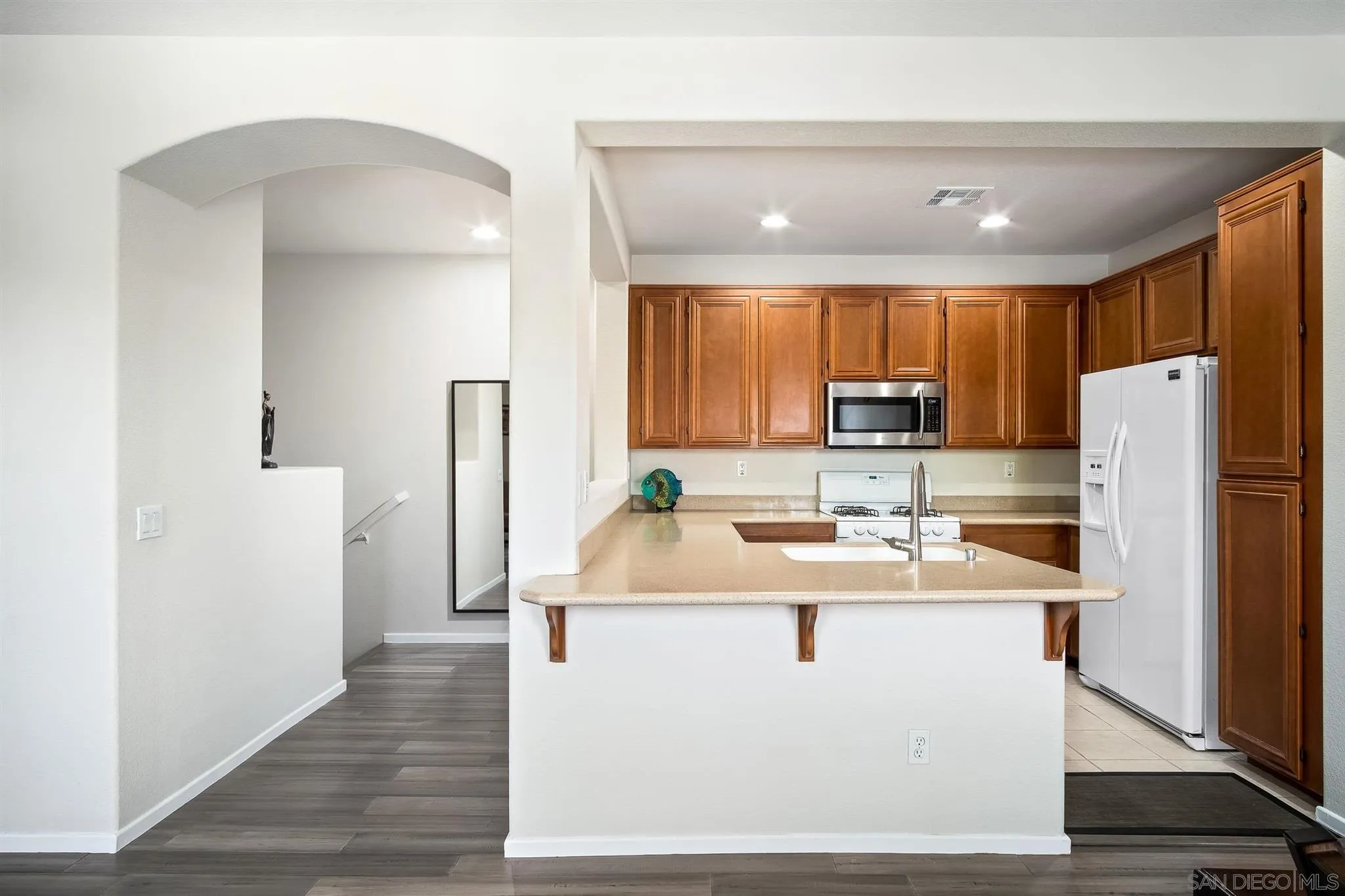 2732 Crown Ridge Road, Unit 1 Chula Vista, CA 91915 - Photo 8 of 32 a kitchen with stainless steel appliances granite countertop a refrigerator a sink a stove and a refrigerator with wooden floor