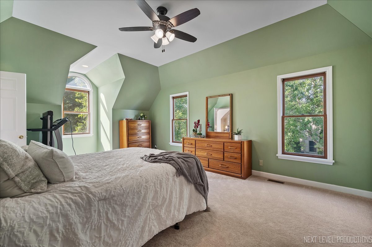 473 Bond Drive Batavia, IL 60510 - Photo 22 of 39 a spacious bedroom with a bed a dresser and a chandelier