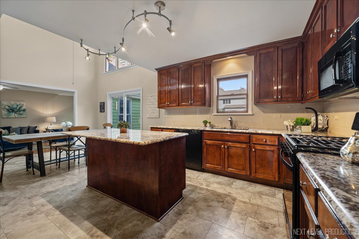 473 Bond Drive Batavia, IL 60510 - Photo 6 of 39 a kitchen with stainless steel appliances granite countertop a stove a sink dishwasher a microwave oven and a dining table with wooden floor