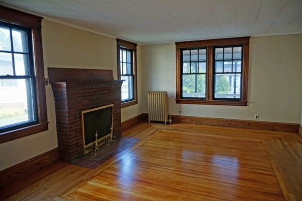 58 Shawmut Street Springfield, MA 01108 - Photo 14 of 26 an empty room with windows fireplace and wooden floor