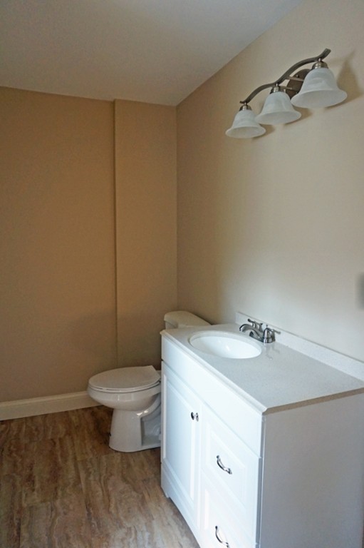 58 Shawmut Street Springfield, MA 01108 - Photo 19 of 26 a bathroom with a granite countertop sink a toilet and a mirror