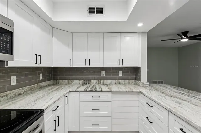 a kitchen with granite countertop a refrigerator and a sink