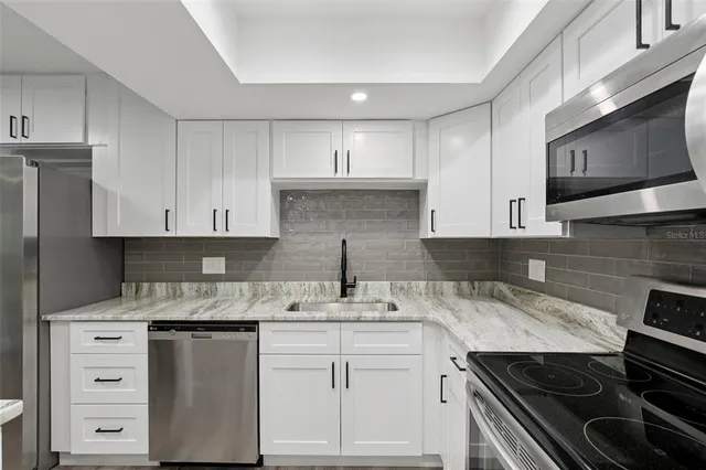 a kitchen with stainless steel appliances a sink cabinets and wooden floor