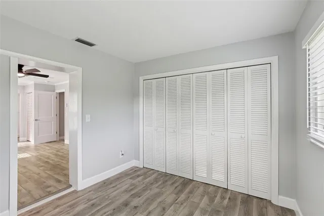 a view of hallway with a ceiling fan and wooden floor
