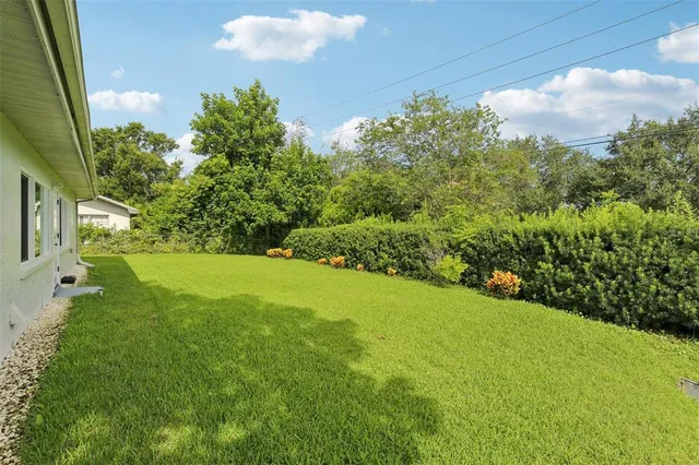 an aerial view of residential houses with outdoor space and trees