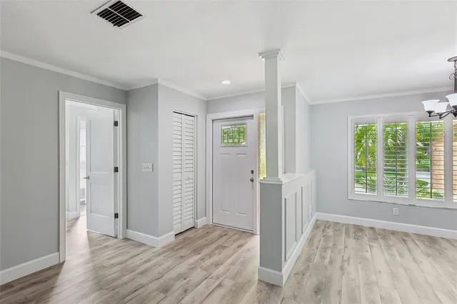 a view of an empty room with wooden floor and a ceiling fan