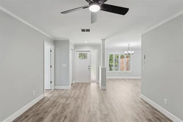 a view of a livingroom with wooden floor and a ceiling fan