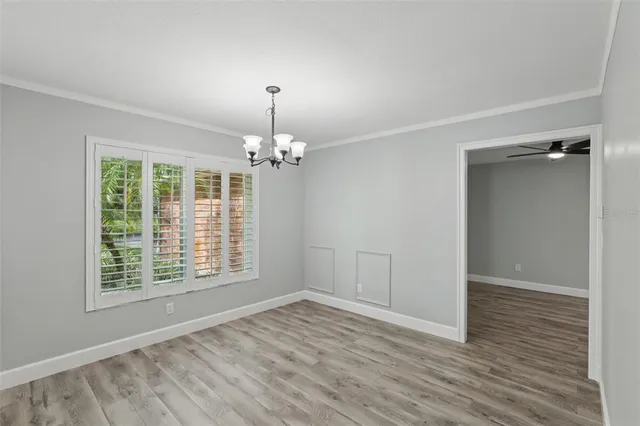 a view of a room with wooden floor and chandelier