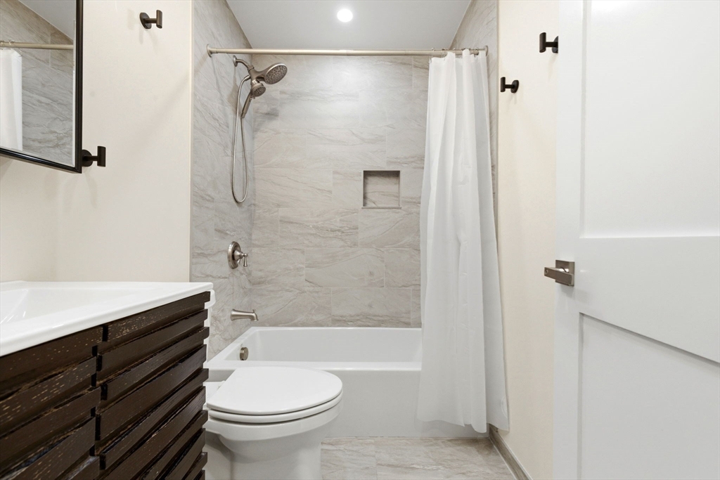 123 Nottinghill Road, Unit 2 Boston, MA 02135 - Photo 15 of 30 a bathroom with a bathtub shower sink vanity and toilet