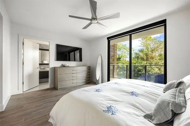 a bedroom with a large bed and a flat tv screen on dresser