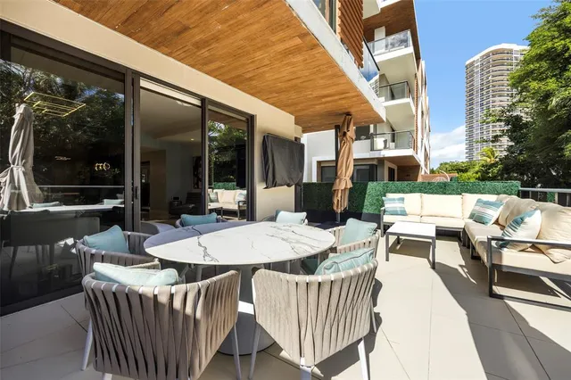 a view of a patio with a dining table and chairs with wooden floor and fence