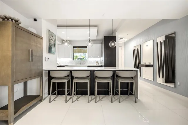 a kitchen with stainless steel appliances kitchen island granite countertop a refrigerator and cabinets