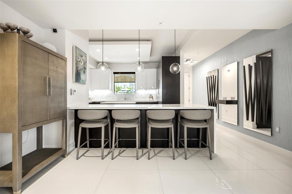 3030 North Ocean Boulevard, Unit S106 Fort Lauderdale, FL 33308 - Photo 8 of 40 a kitchen with stainless steel appliances kitchen island granite countertop a refrigerator and cabinets