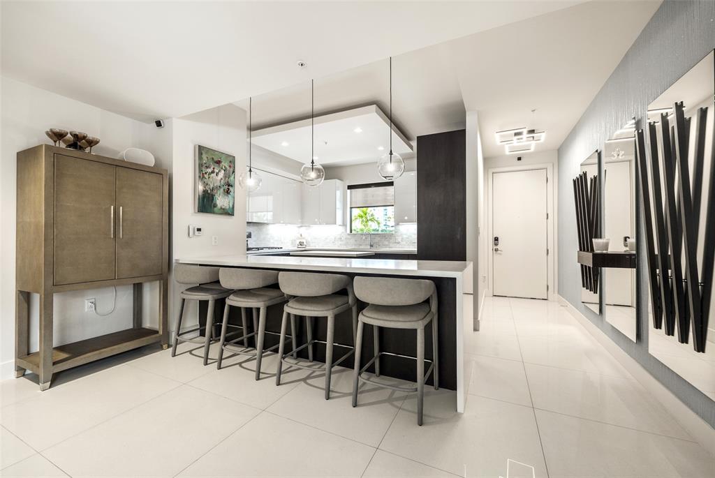 3030 North Ocean Boulevard, Unit S106 Fort Lauderdale, FL 33308 - Photo 9 of 40 a large kitchen with a table and chairs